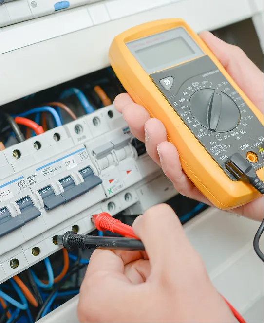 Elektriker misst mit einem Multimeter im Sicherungskasten